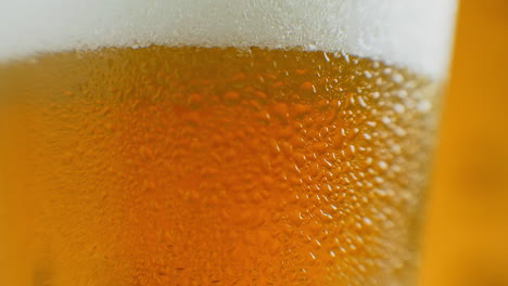 Cámara-Lenta-De-Primer-Plano:-Cerveza-Fría-En-Un-Vaso,-Gotas-Grandes-Y-Burbujas-En-La-Cerveza
